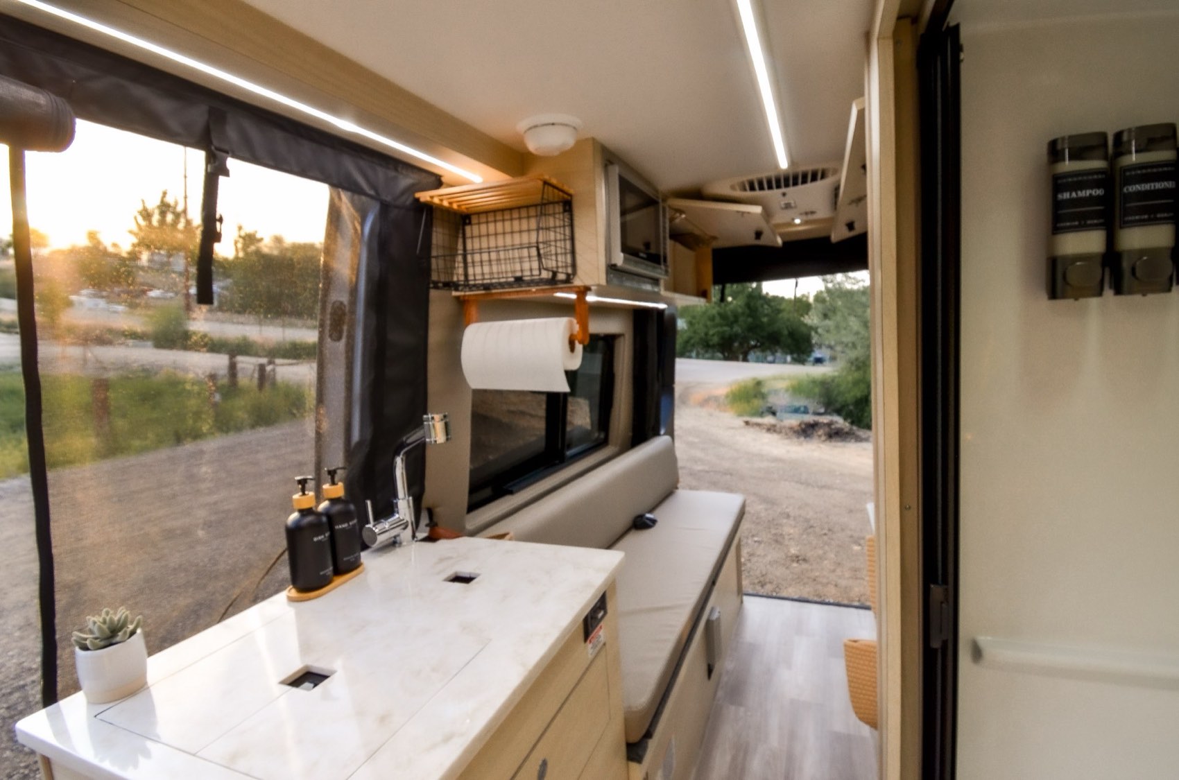 Galley and bench seating with the sliding door open at golden hour