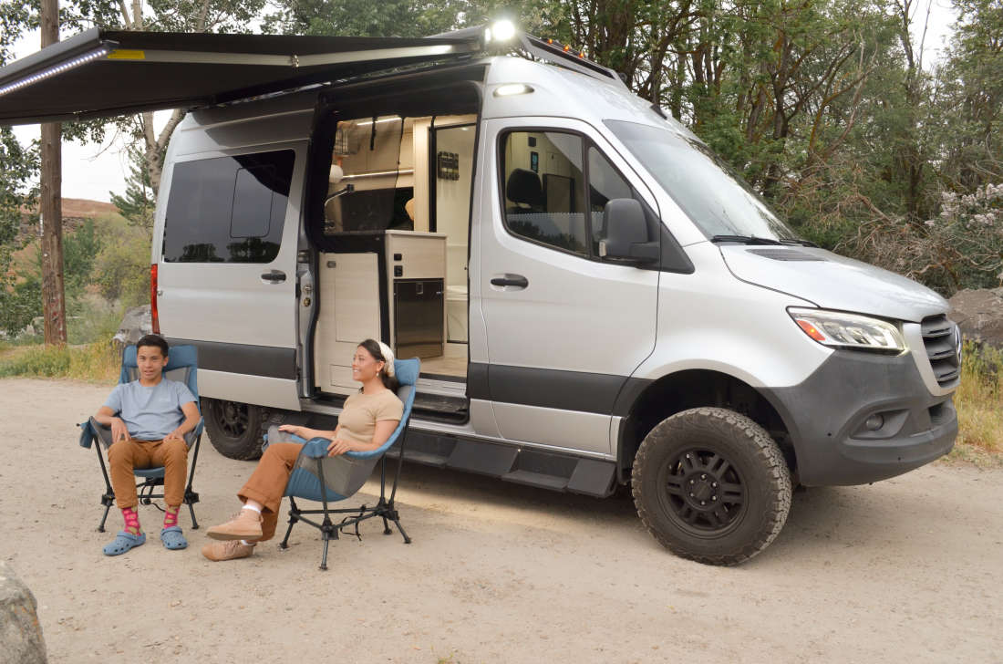 The van with its awning extended and camping chairs set out