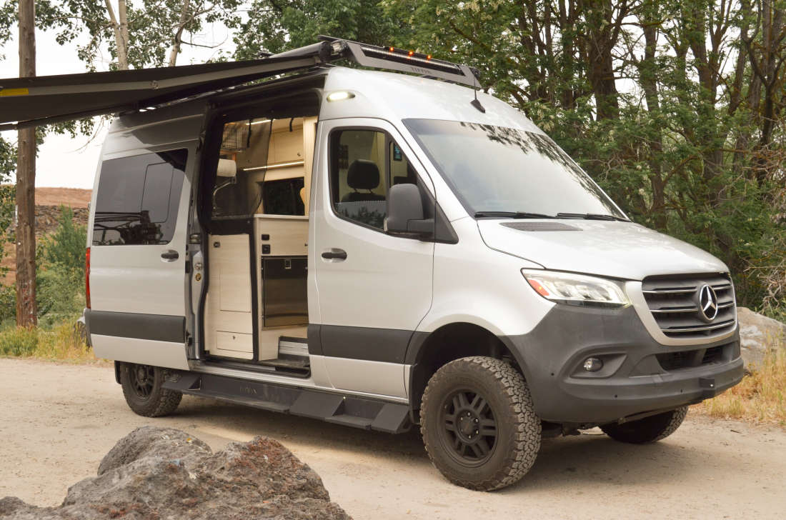 The van at camp with awning out and the side door open