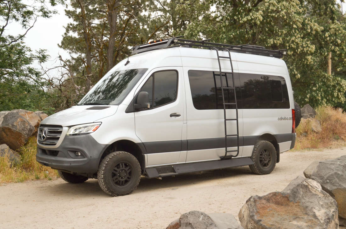 Roameo on a dirt track among boulders and pines, showing its all-terrain tires and 4x4 stance