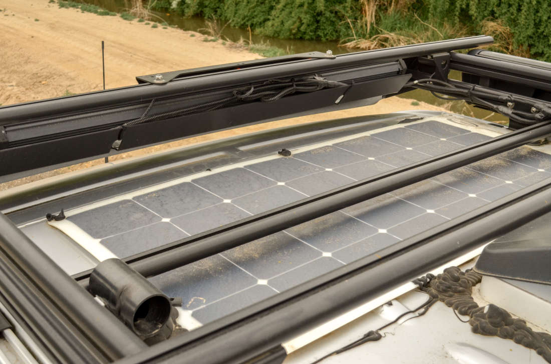 Roof-mounted solar panel between the rack rails